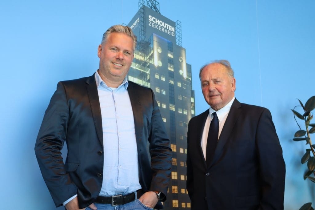 Herjo Gerritsen (links) en Jan Hoeflaak voor een foto van het hoofdkantoor in Rotterdam